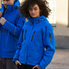 Two people wearing blue jackets standing outdoors.