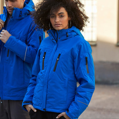 Two people wearing blue jackets standing outdoors.