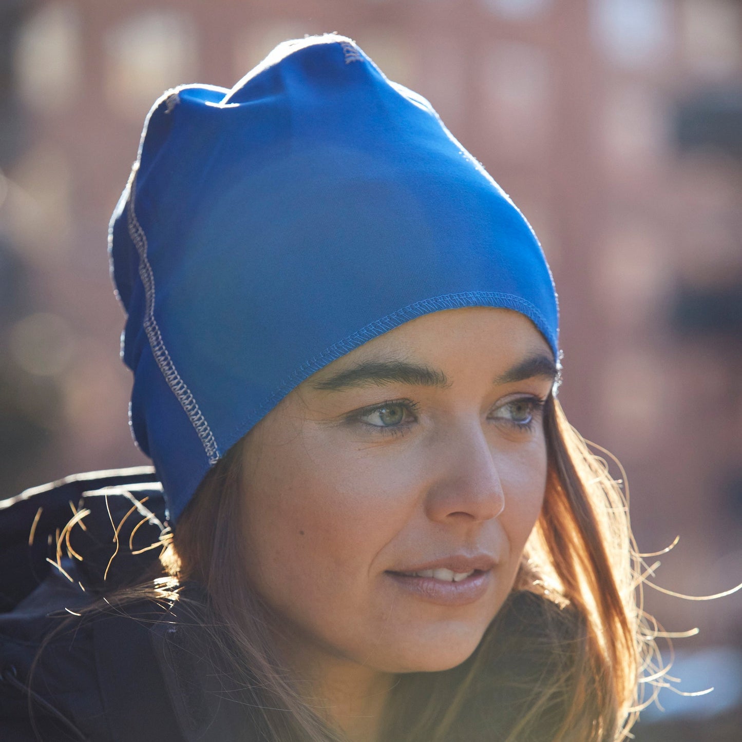 Woman wearing a blue beanie with a blurred background
