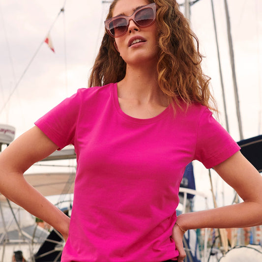 Woman wearing a bright pink t-shirt and sunglasses