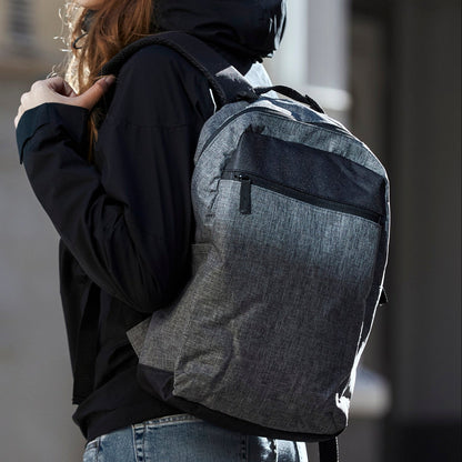 Person wearing a gray backpack in an urban setting