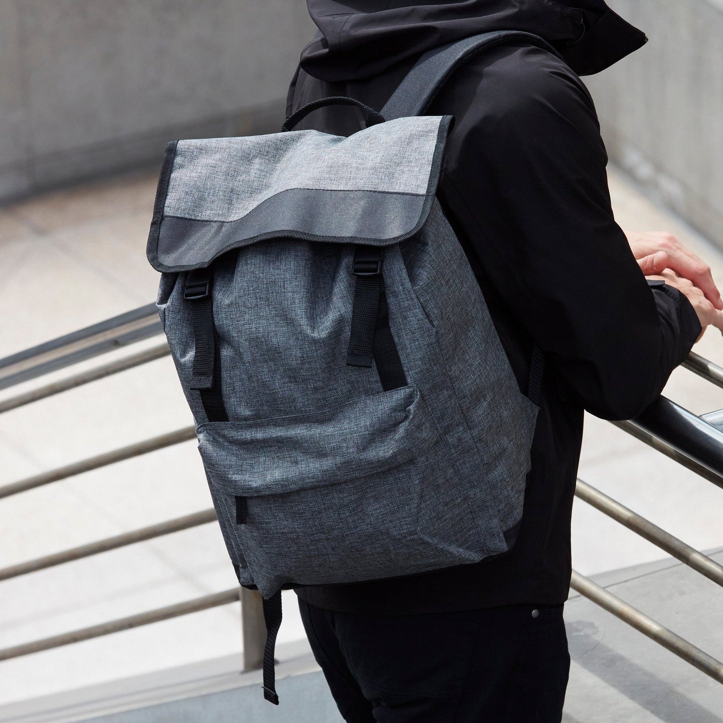 Man with a gray backpack walking on a staircase