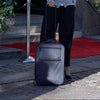 Woman with a suitcase standing outside a building entrance