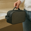 Person holding a black travel case in an indoor setting